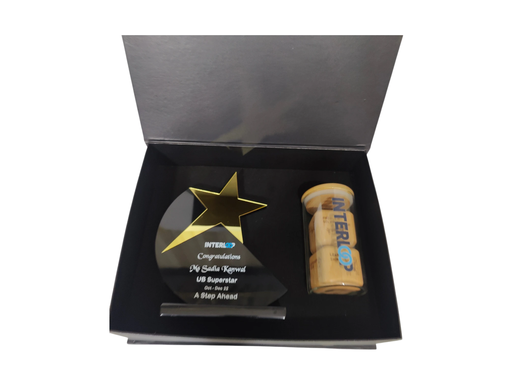Custom employee recognition award set with a star-shaped acrylic trophy and branded desktop accessories.
