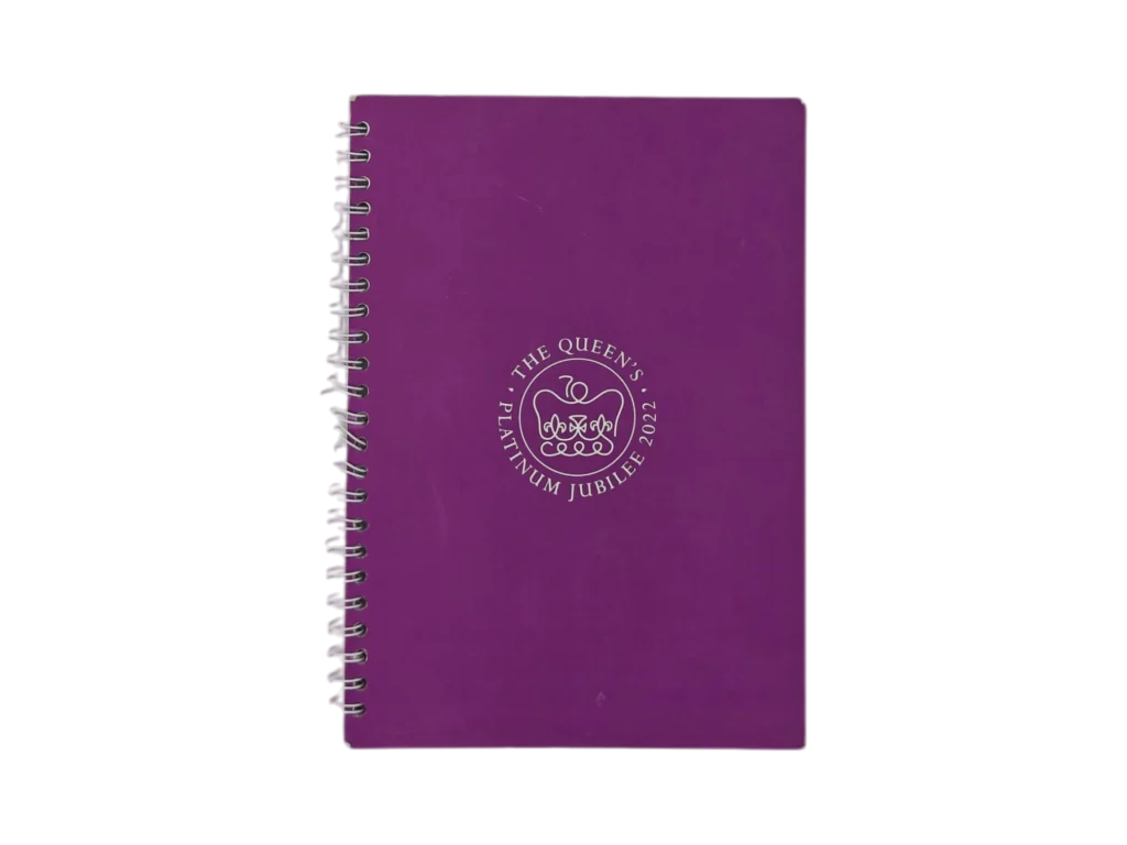 Custom royal purple spiral notebook with embossed commemorative seal for corporate gifting.